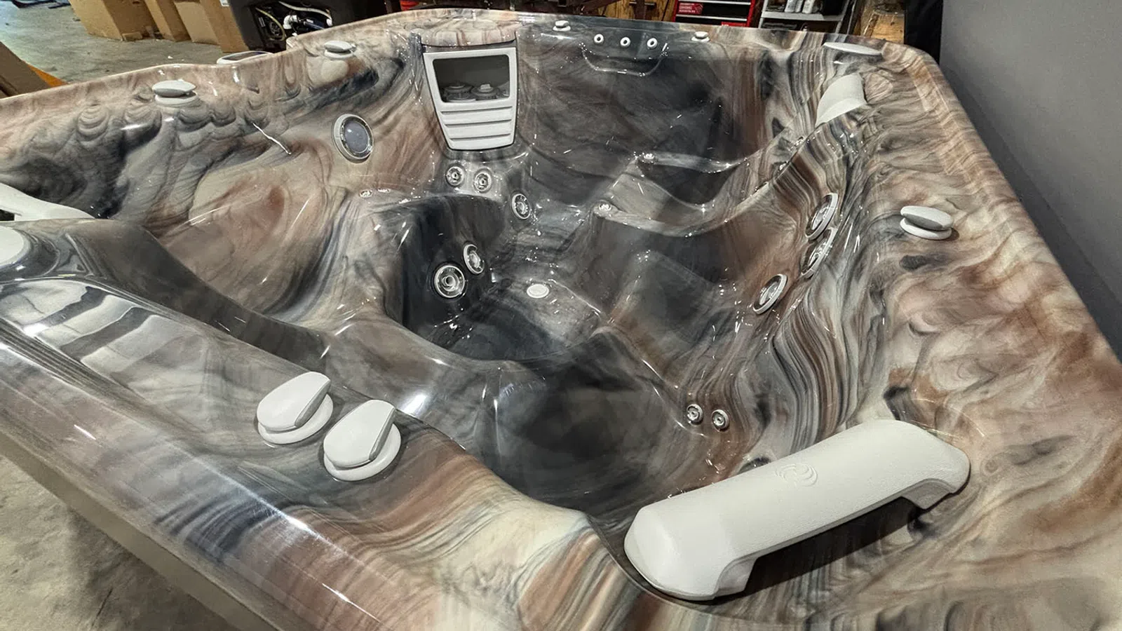 Marble-patterned multi-seat hot tub with built-in jets, headrests, and ergonomic seating in a showroom.
