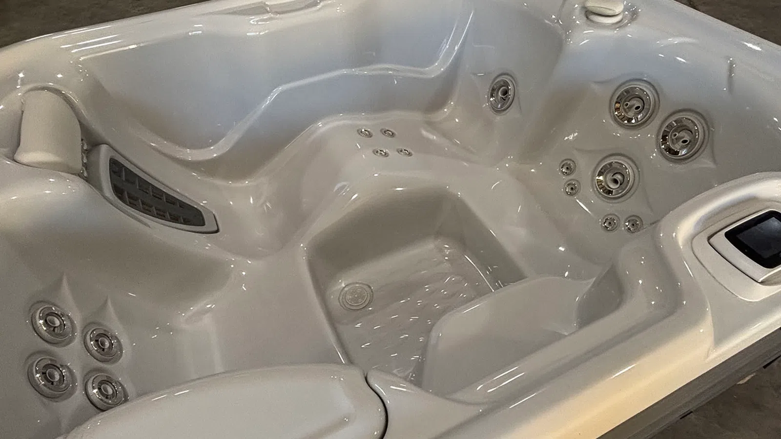 White acrylic hot tub with multiple jet nozzles and contoured seating for relaxation and hydrotherapy.