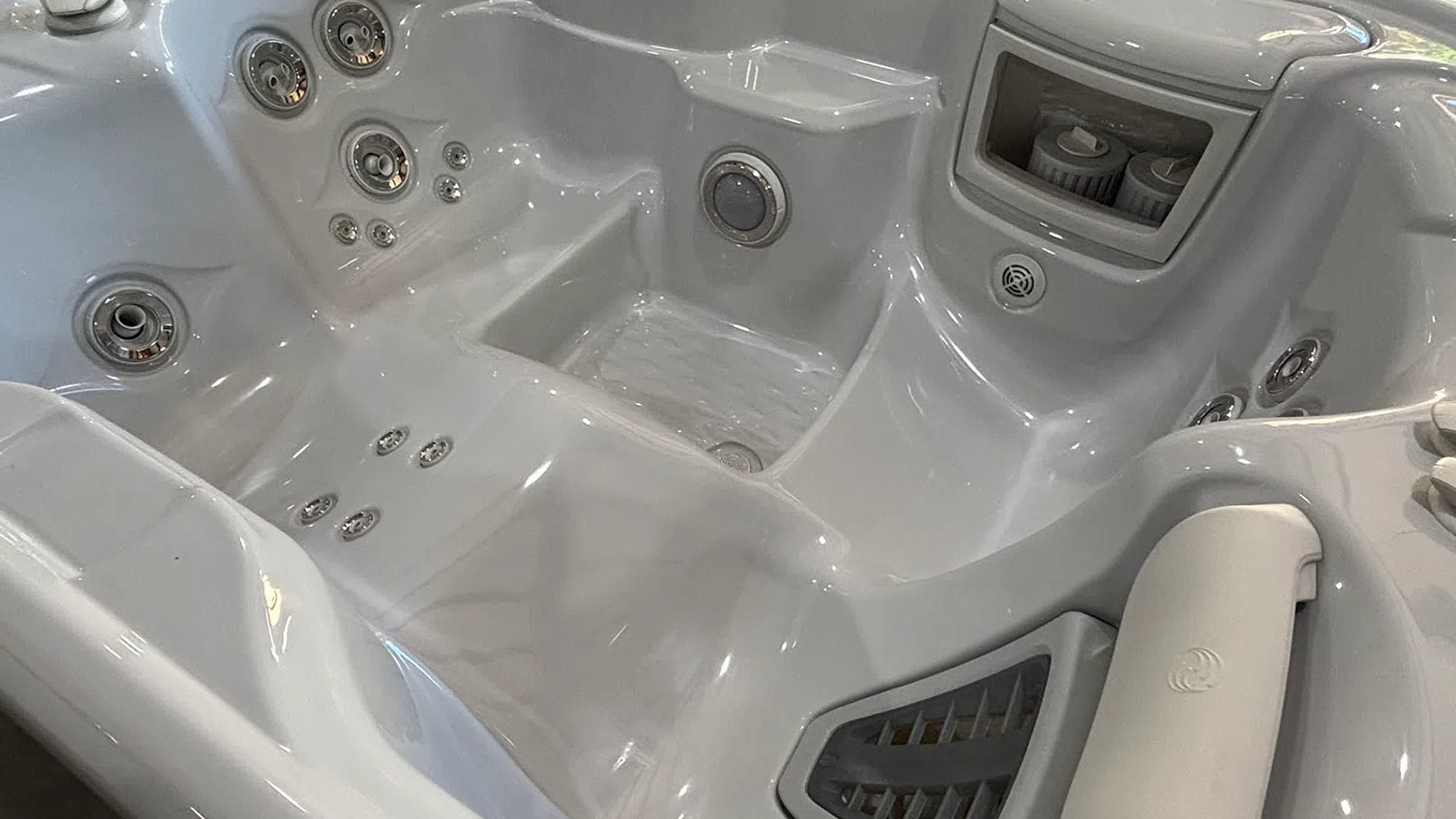 Interior view of a clean, white hot tub with multiple jets and contoured seating for comfort.