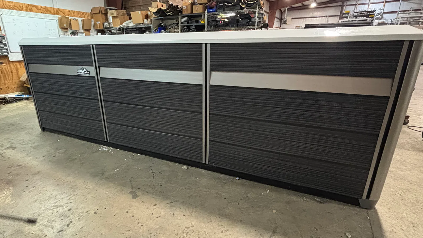 Large industrial black and gray storage cabinet with horizontal panel doors in a warehouse setting.