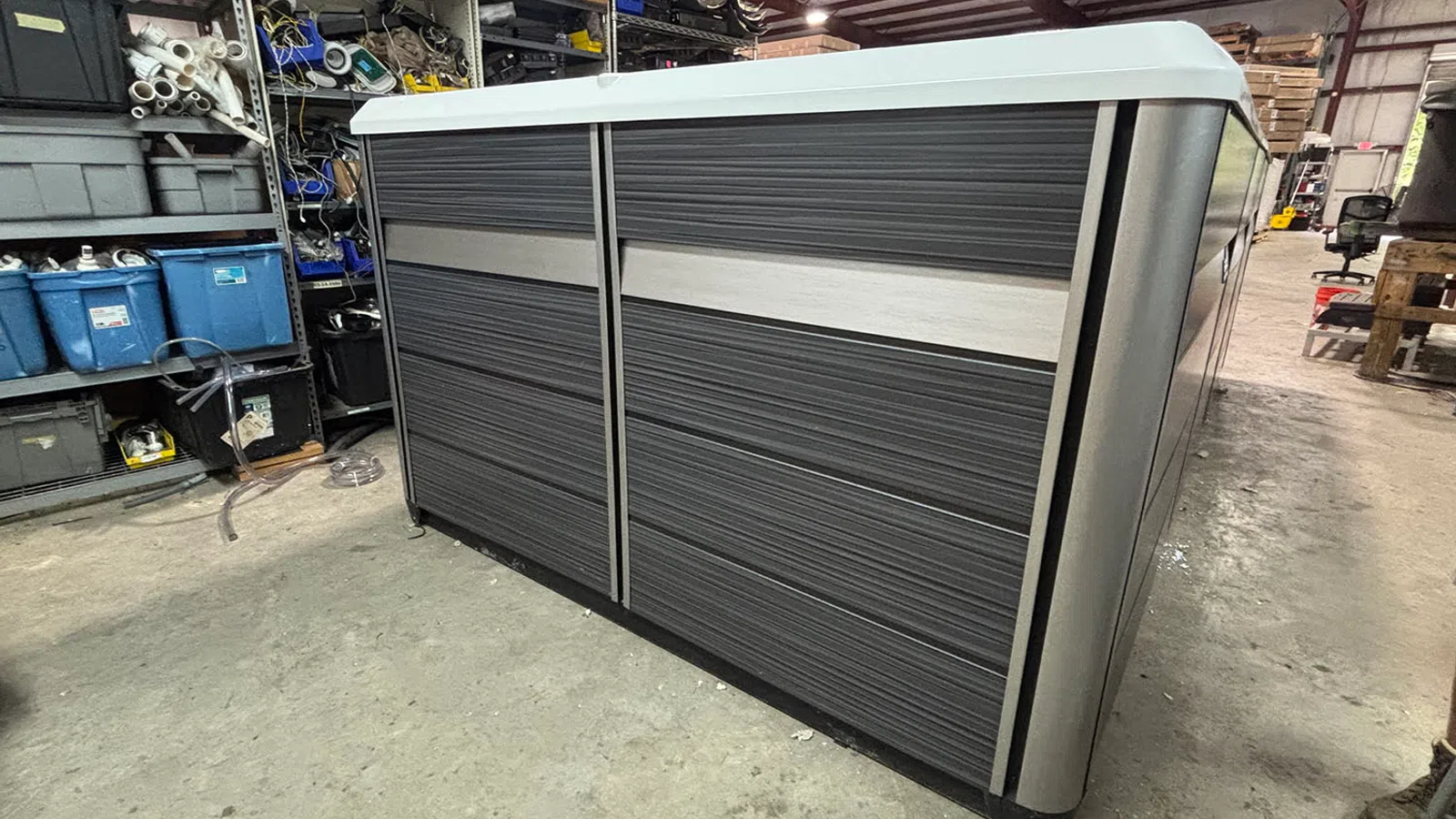 Modern gray and white storage cabinet with textured panels in an industrial warehouse setting.