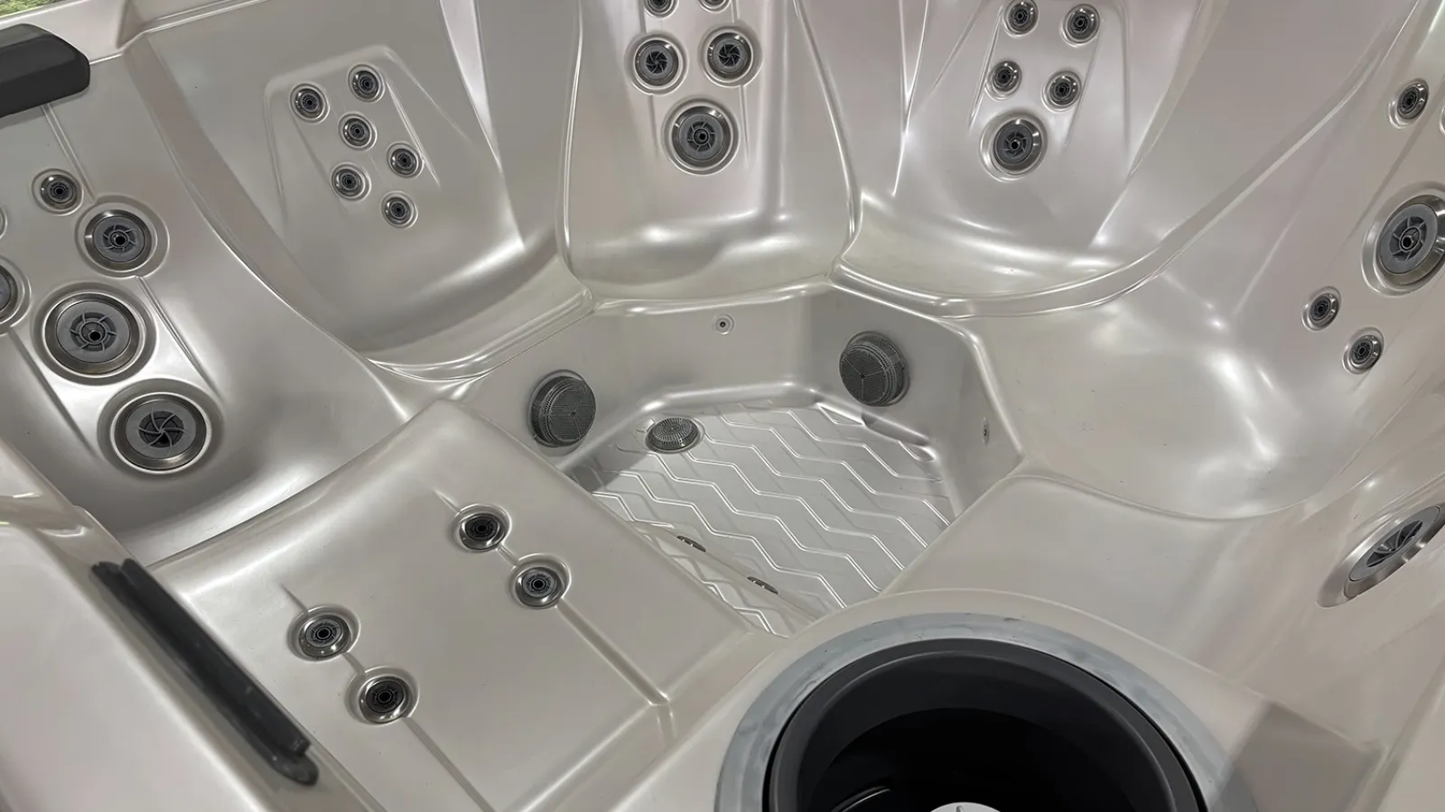Interior close-up of a luxury hot tub with multiple water jets and ergonomic seating design.