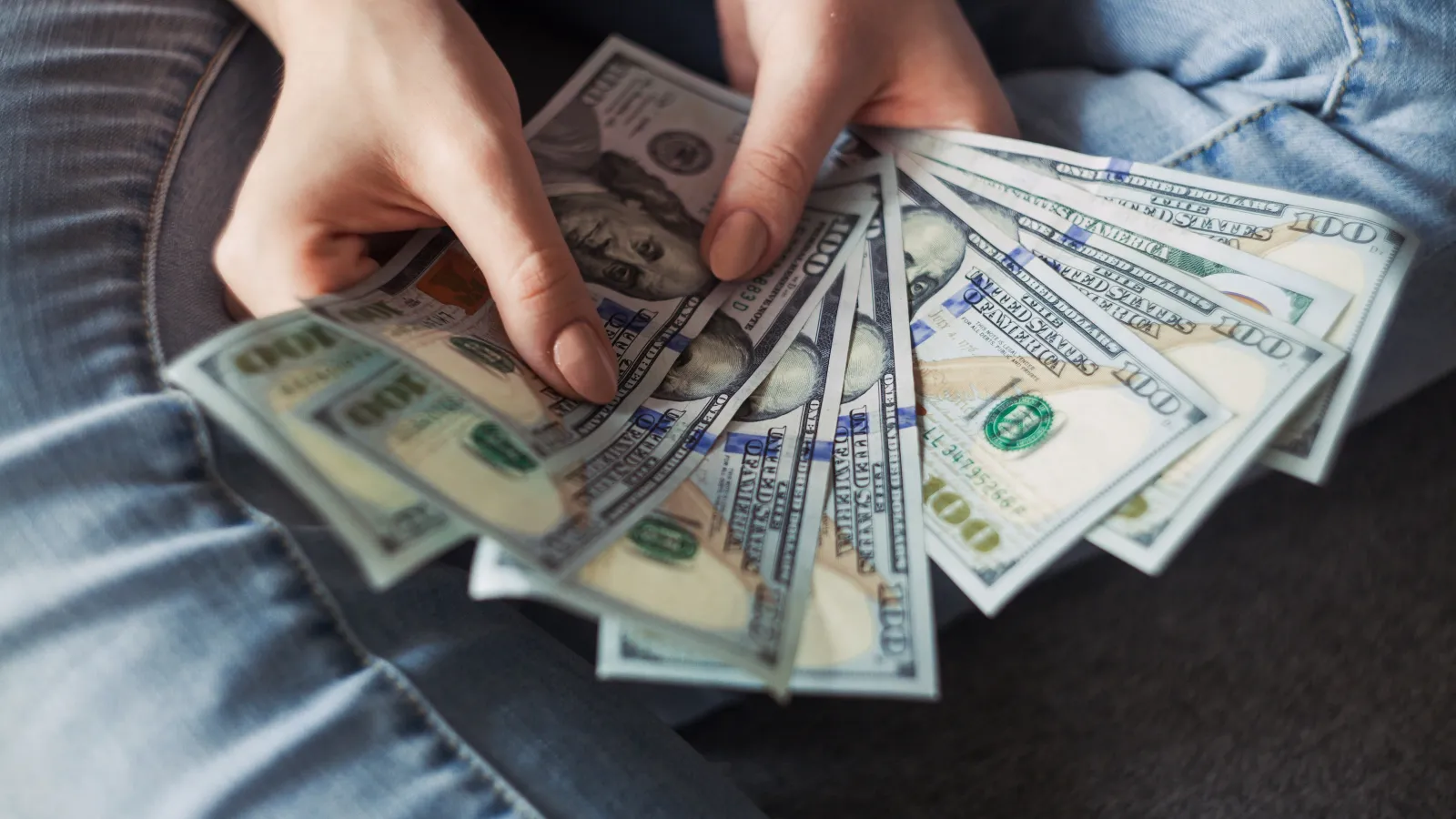 a person holding a stack of paper money