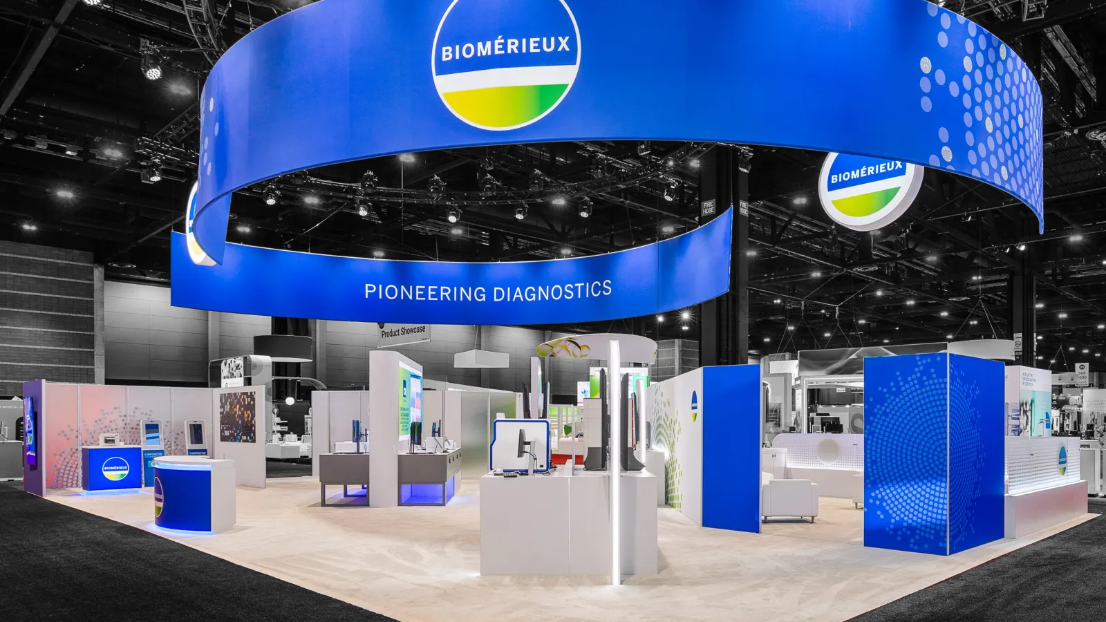Exhibition booth of bioMérieux with large blue circular banner and diagnostic technology displays in a convention center.