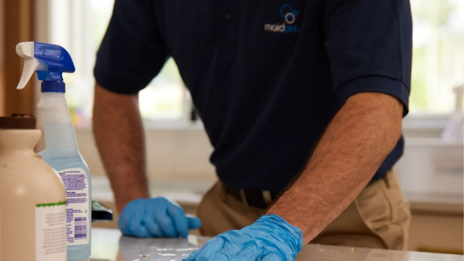 a man wearing gloves and a blue shirt working on a piece of paper