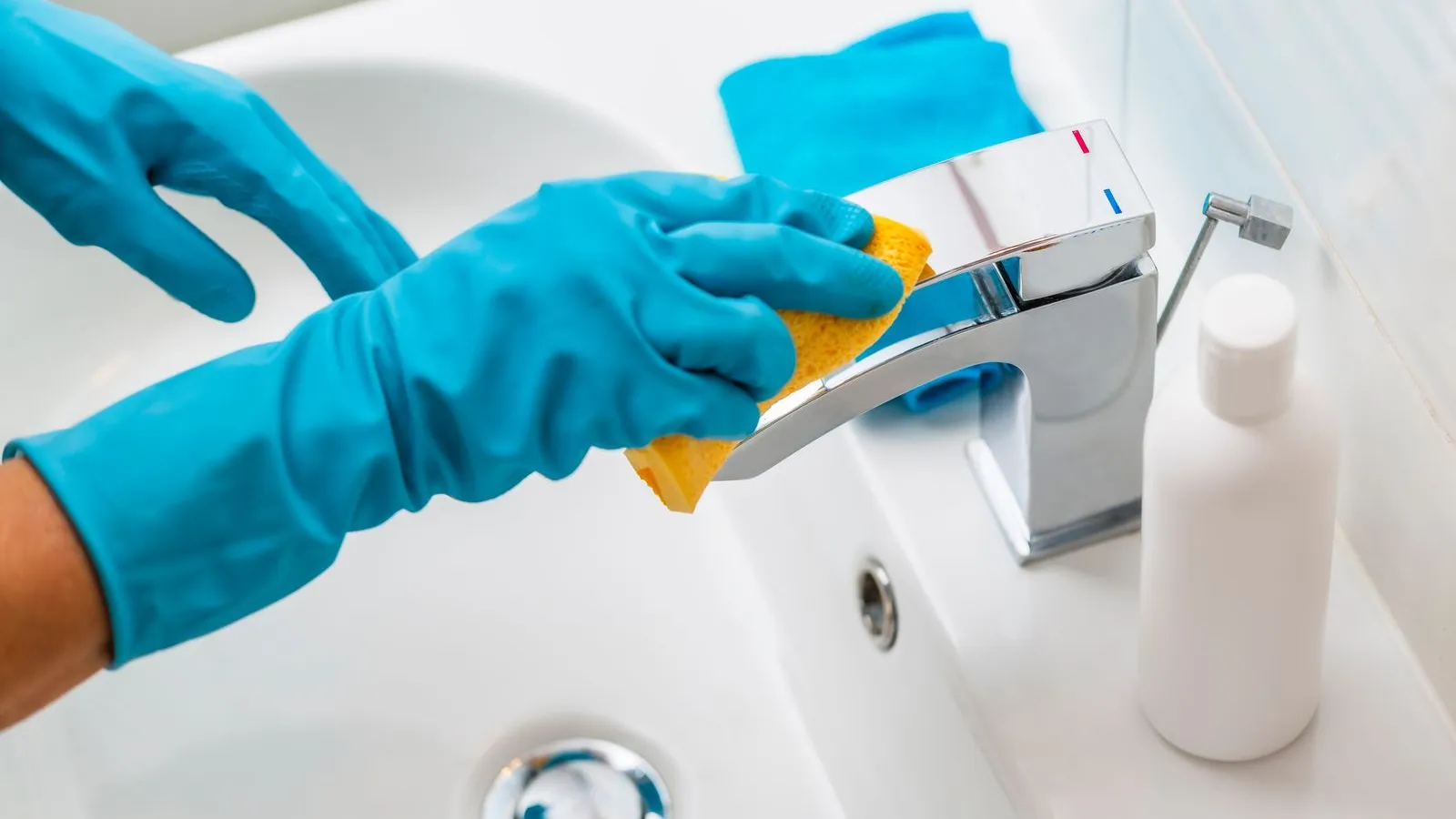 a person in a blue glove holding a container with a liquid in it