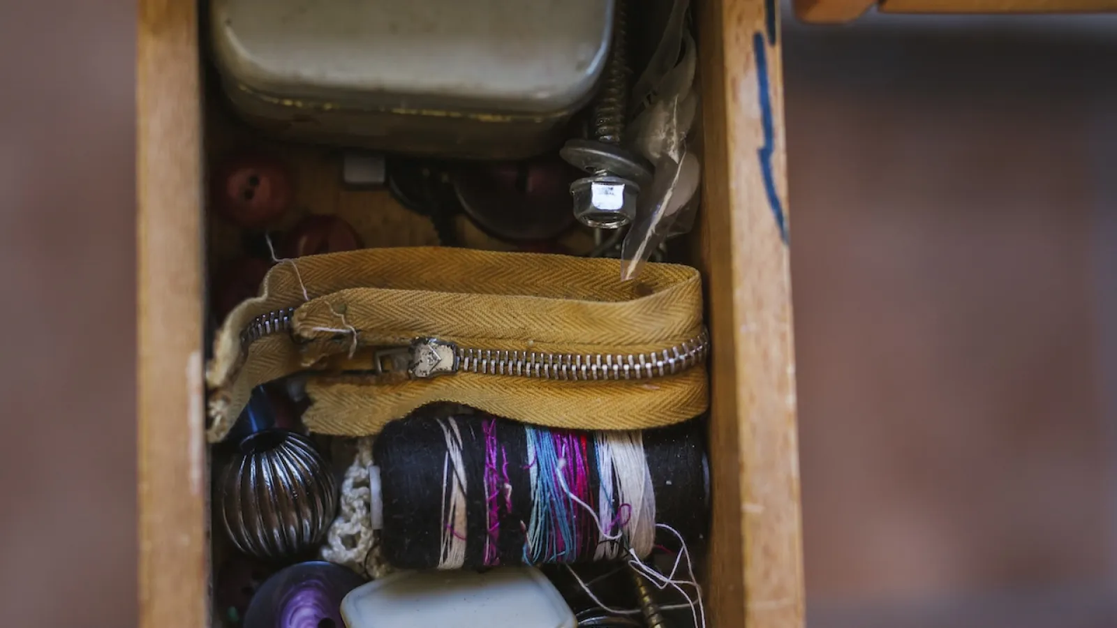 a hand holding a small box with a variety of items inside