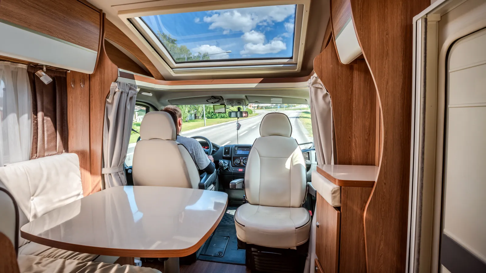 a couple of people sitting in a camper looking out the window