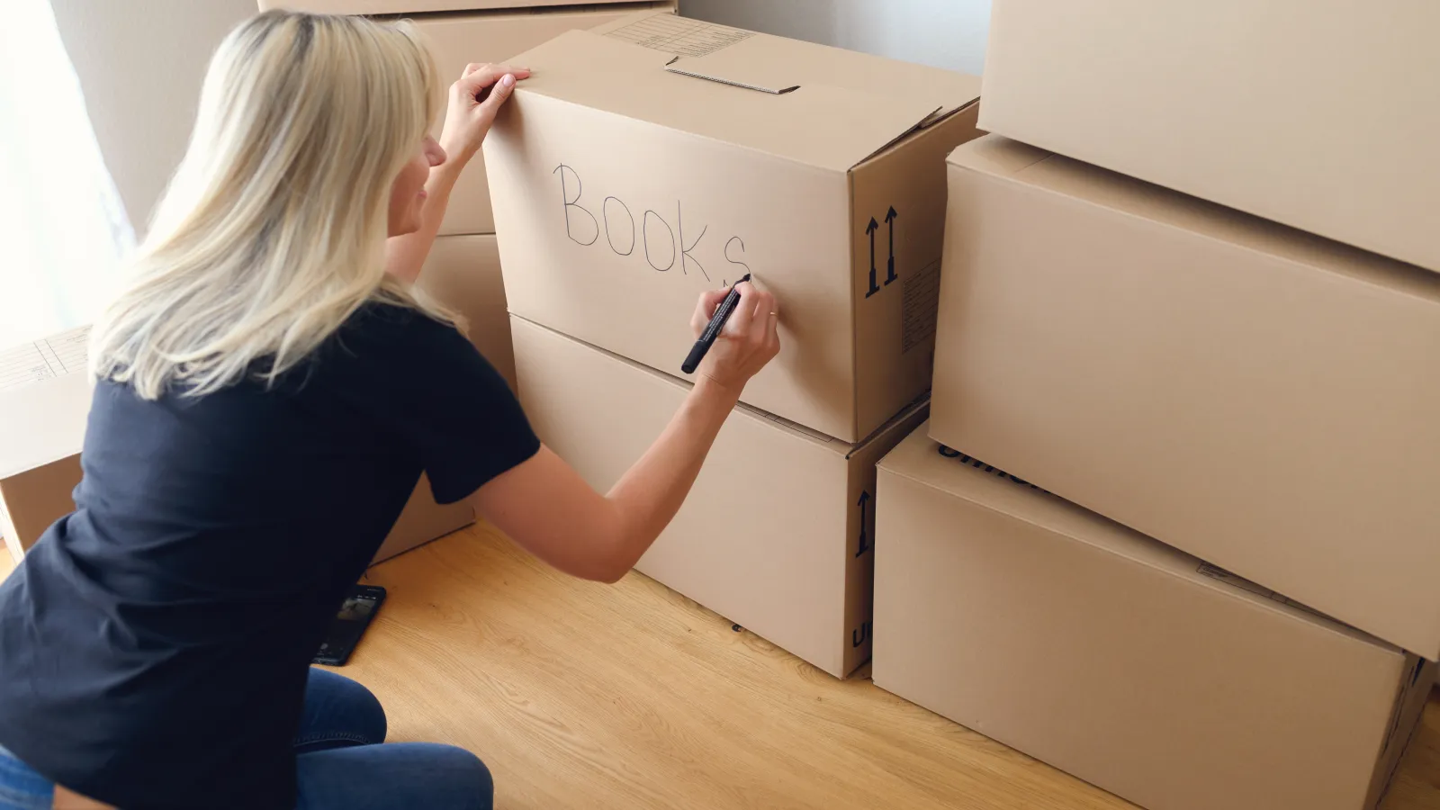 woman labeling boxes to bring to self storage facility