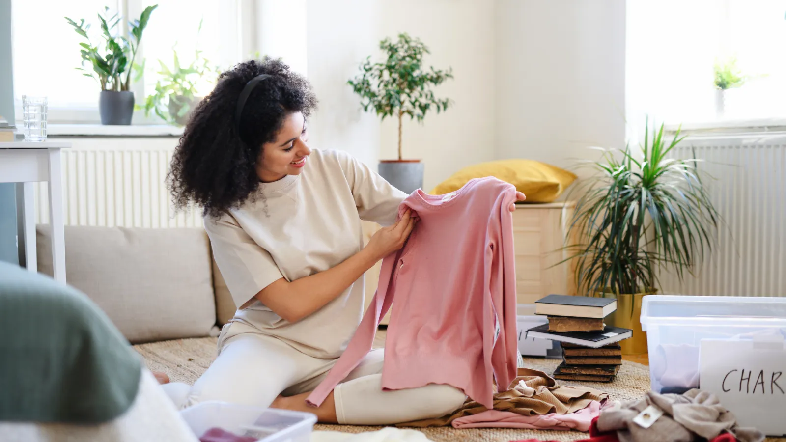 young woman decluttering clothes and books