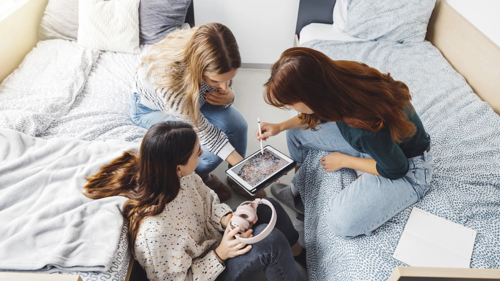 a group of women sitting in college dorm room