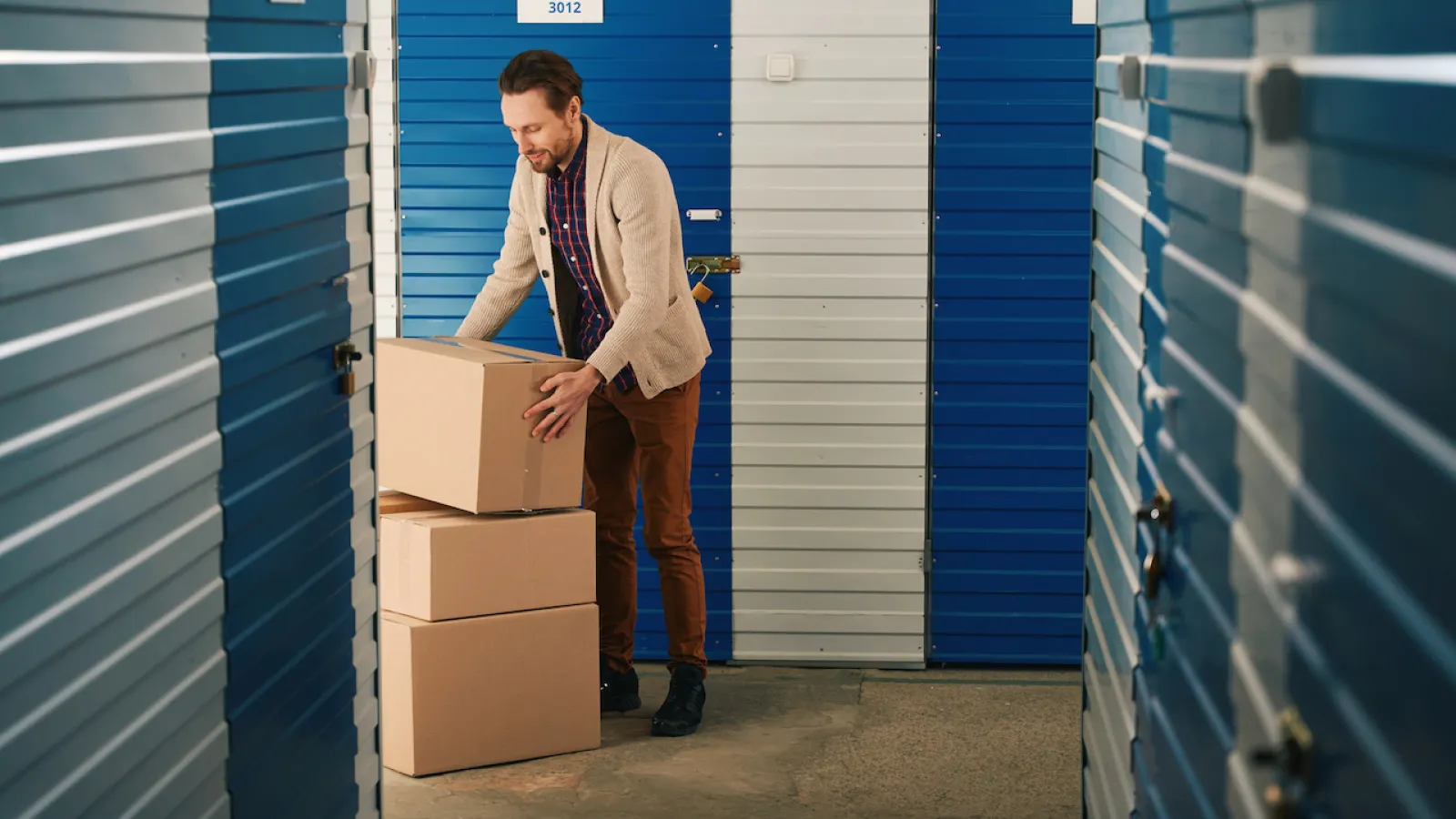 guy with cardboard boxes moving to climate-controlled storage