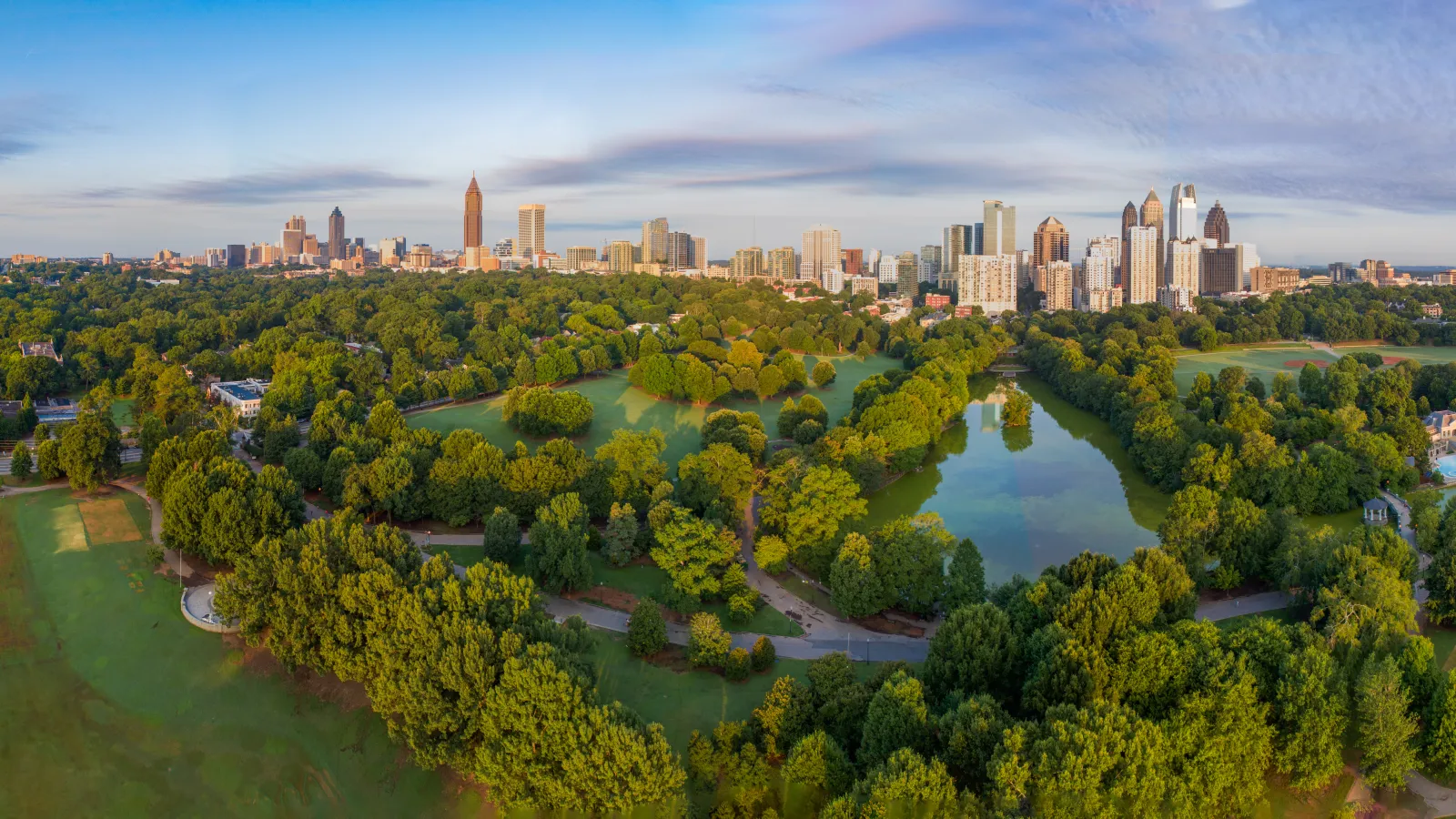 a park with trees and a city in the background
