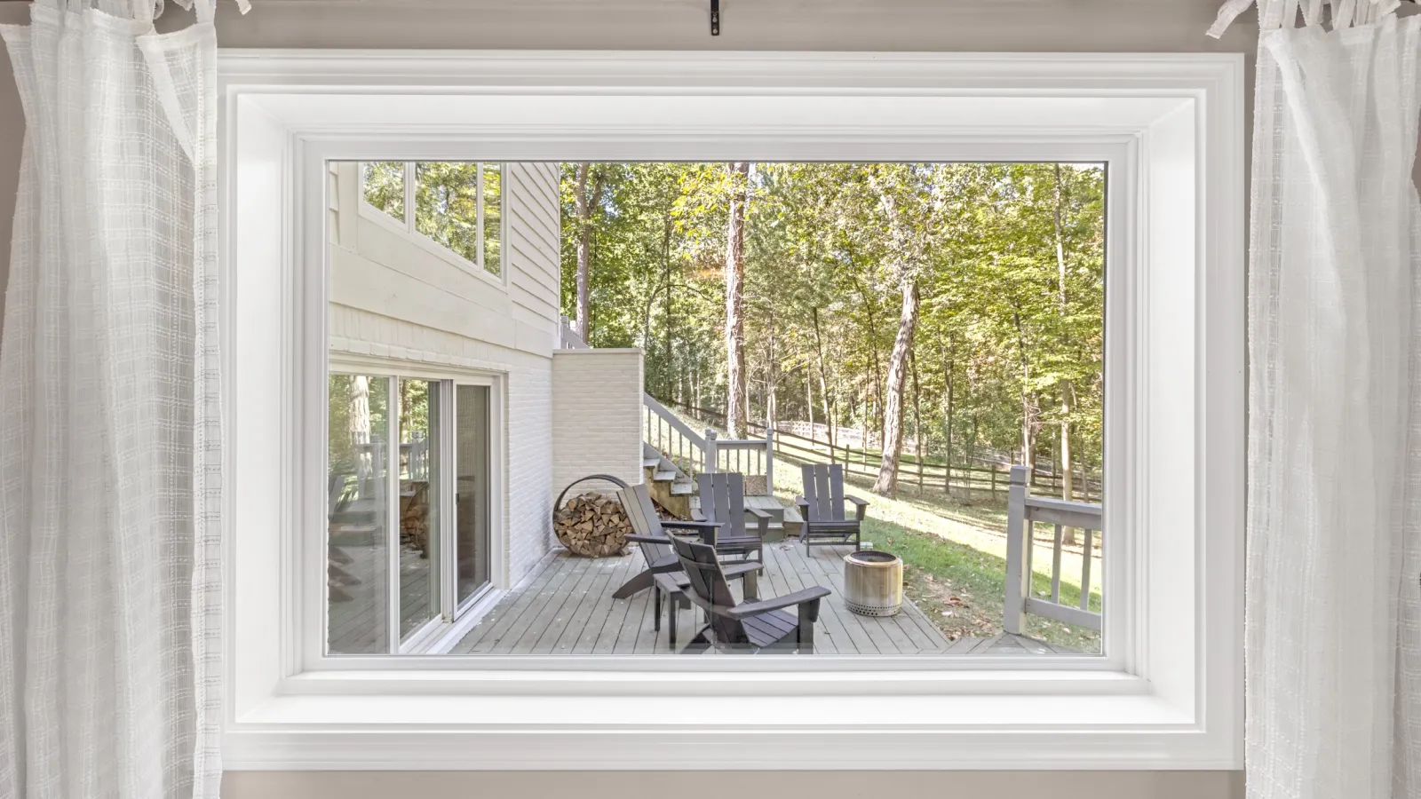 a window with a view of trees and a patio