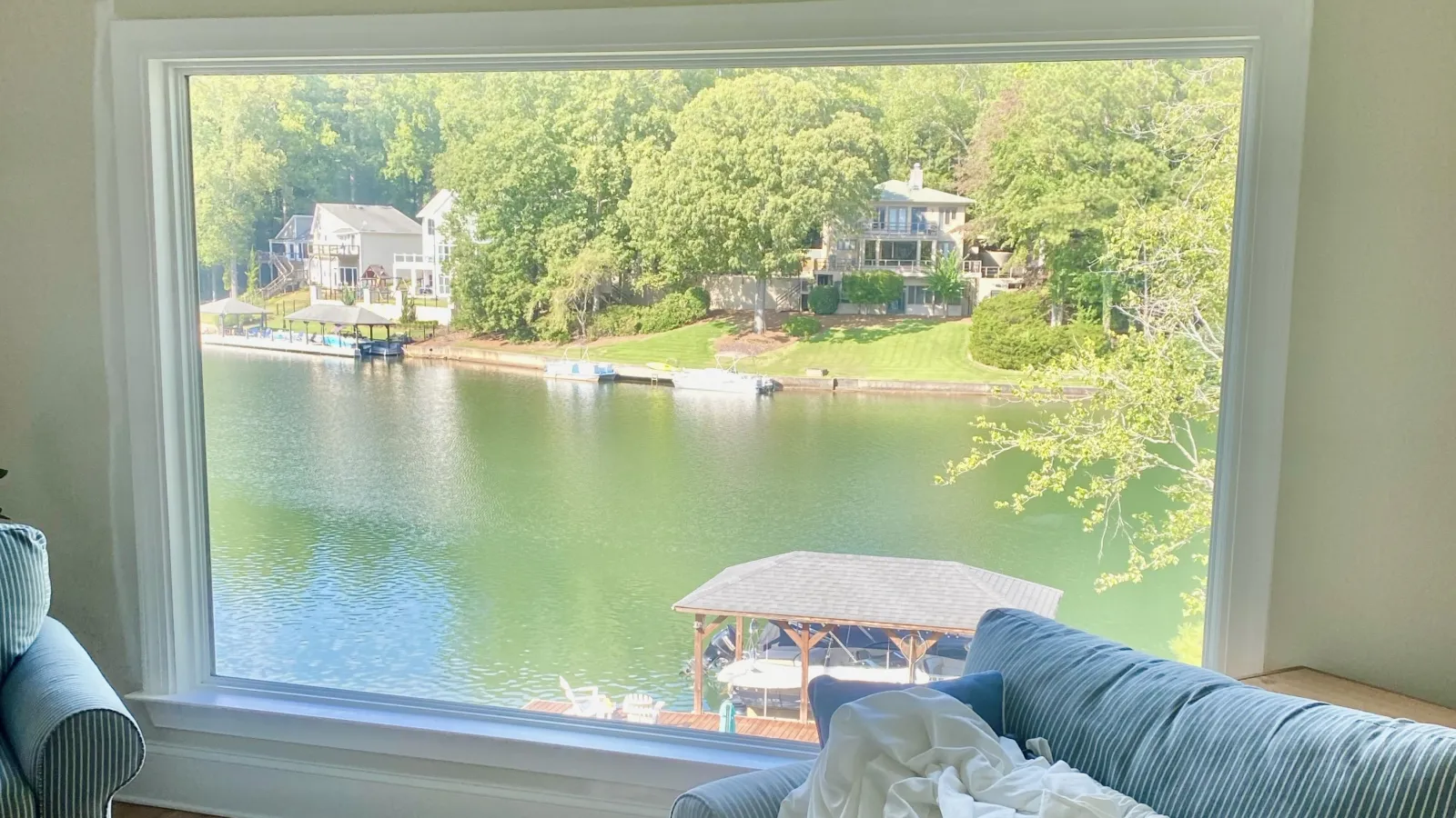 a room with a table and chairs and a body of water