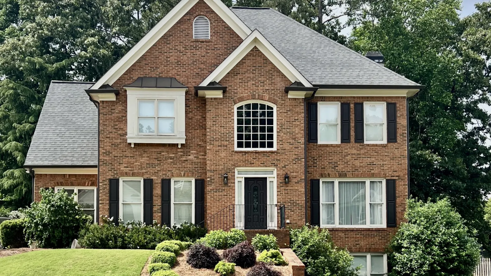 a brick house with a large front yard