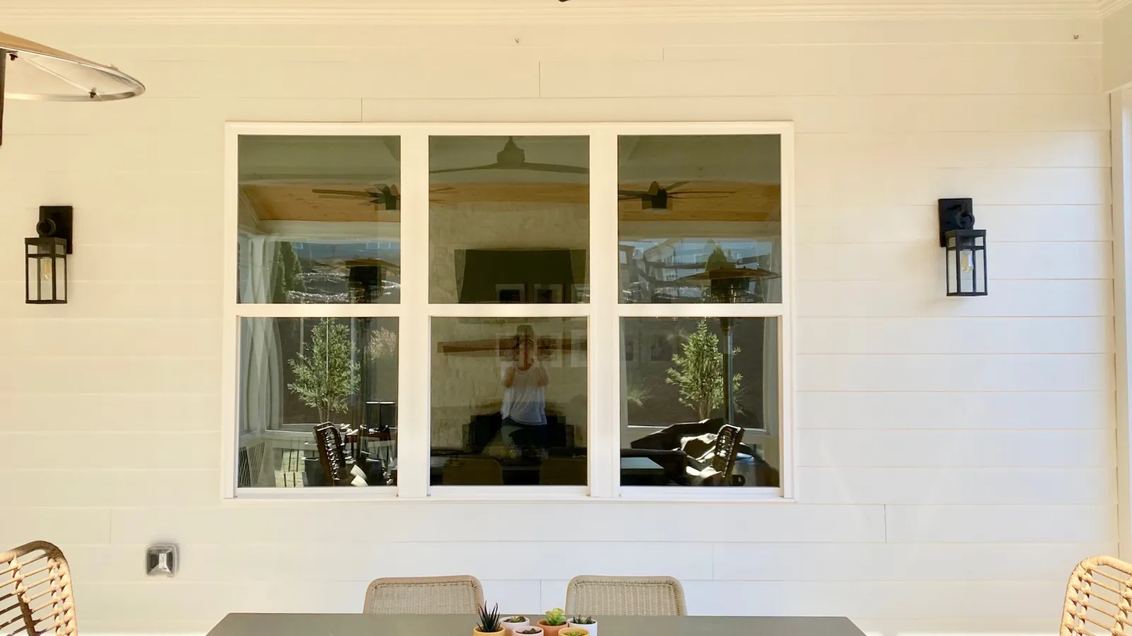 Patio table in front of 3 white double hung windoes