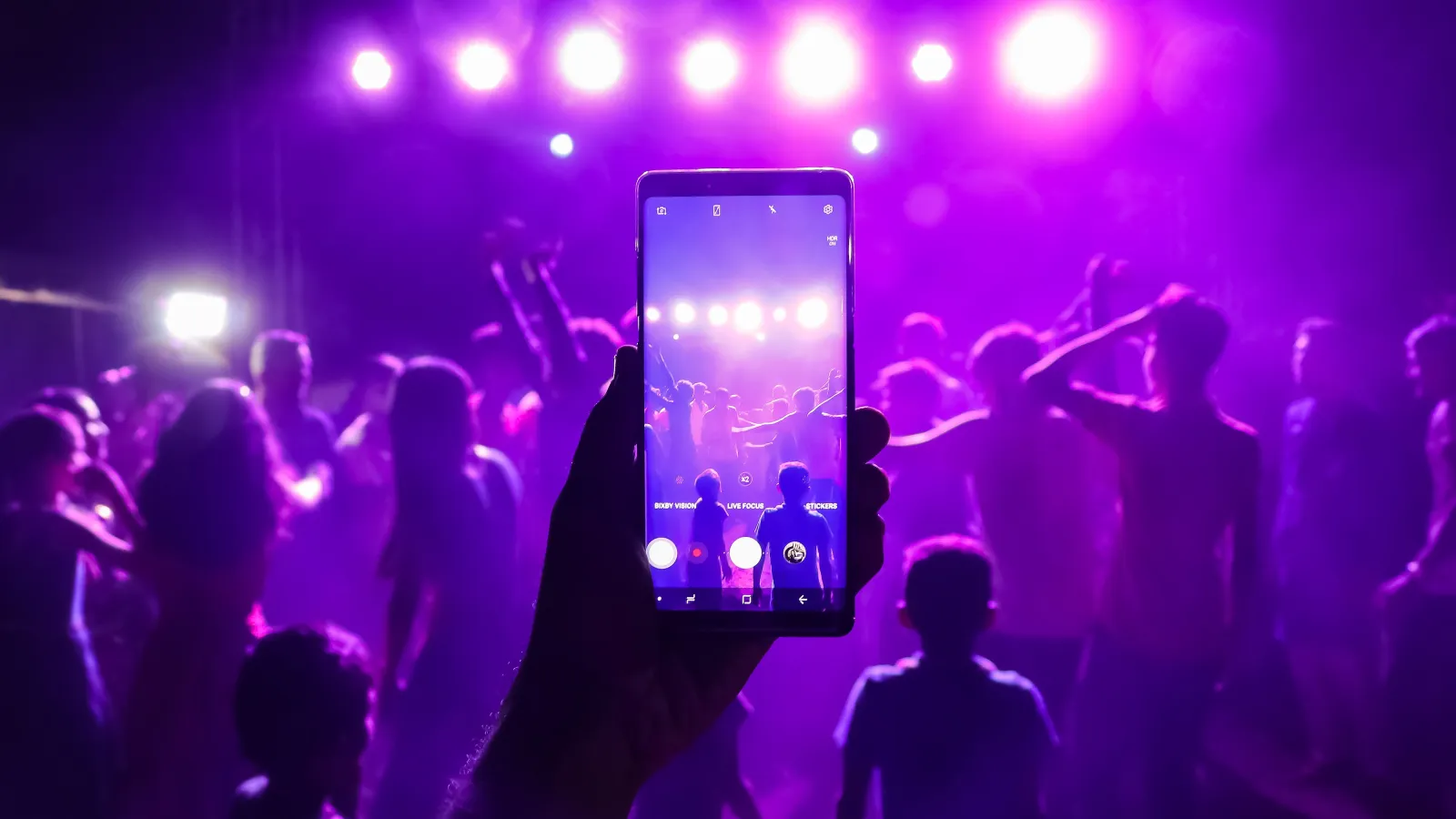 a person holding a phone in front of a crowd of people