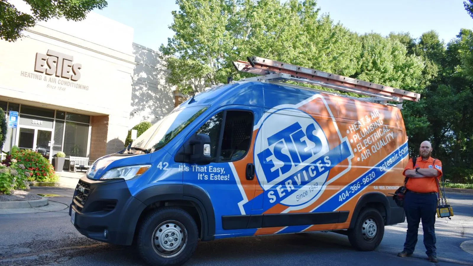 Estes Services van parked outside Estes Heating and Air Conditioning building with technician standing beside it.