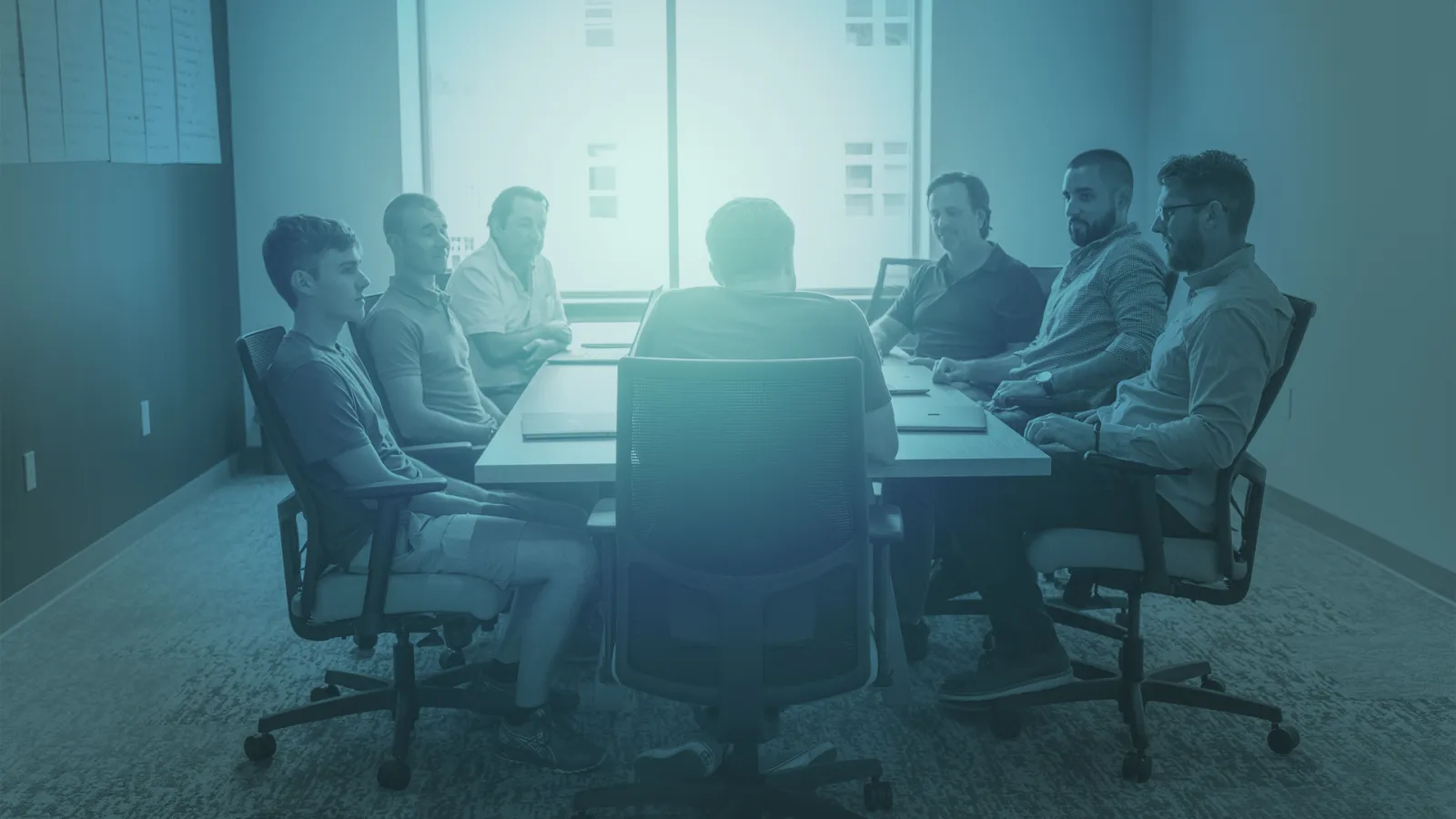 a group of people sitting in a chair in front of a laptop