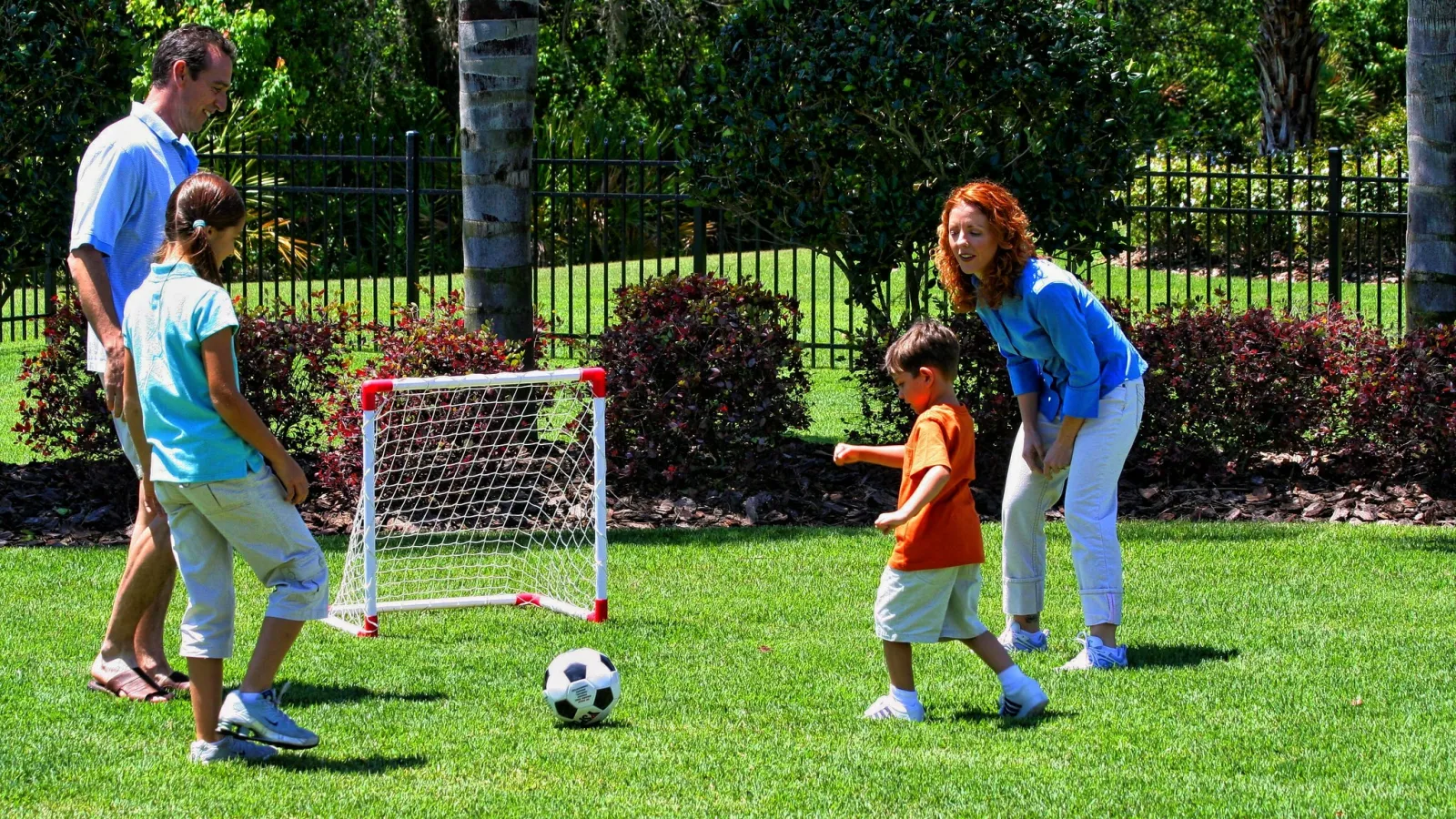 family playing soccer in yard