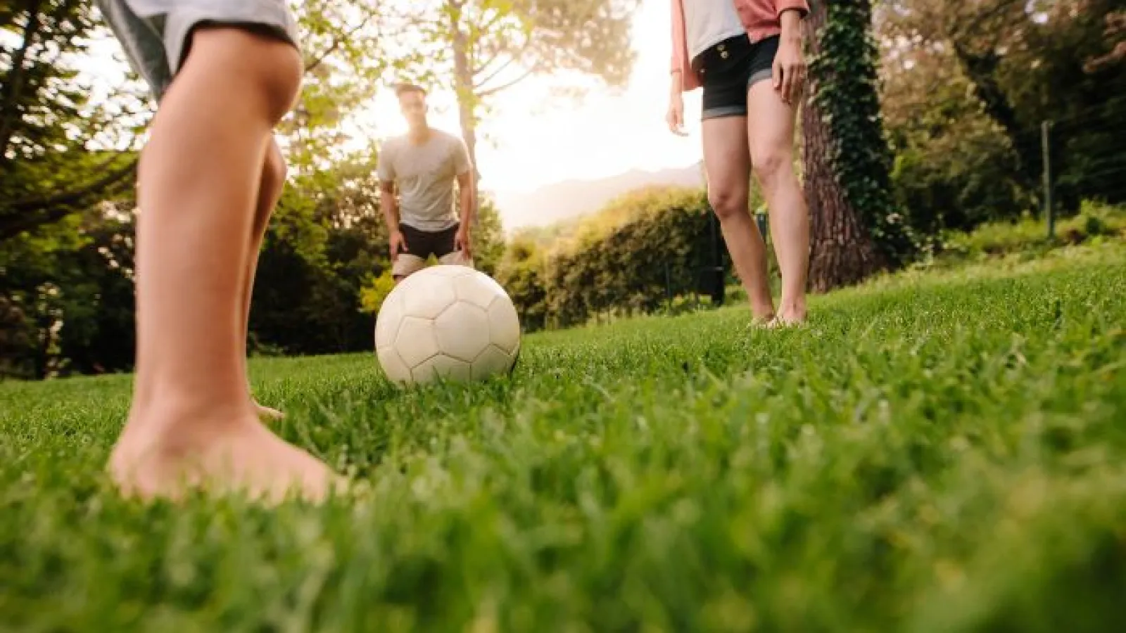 a group of people playing soccer in lawn