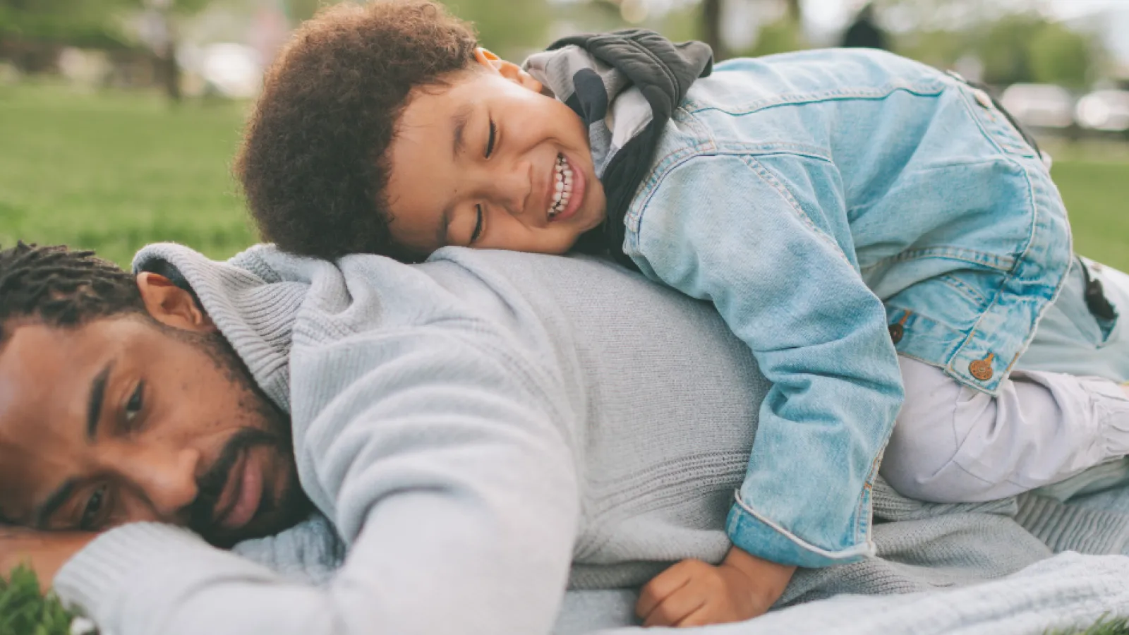 father and son lying in grass