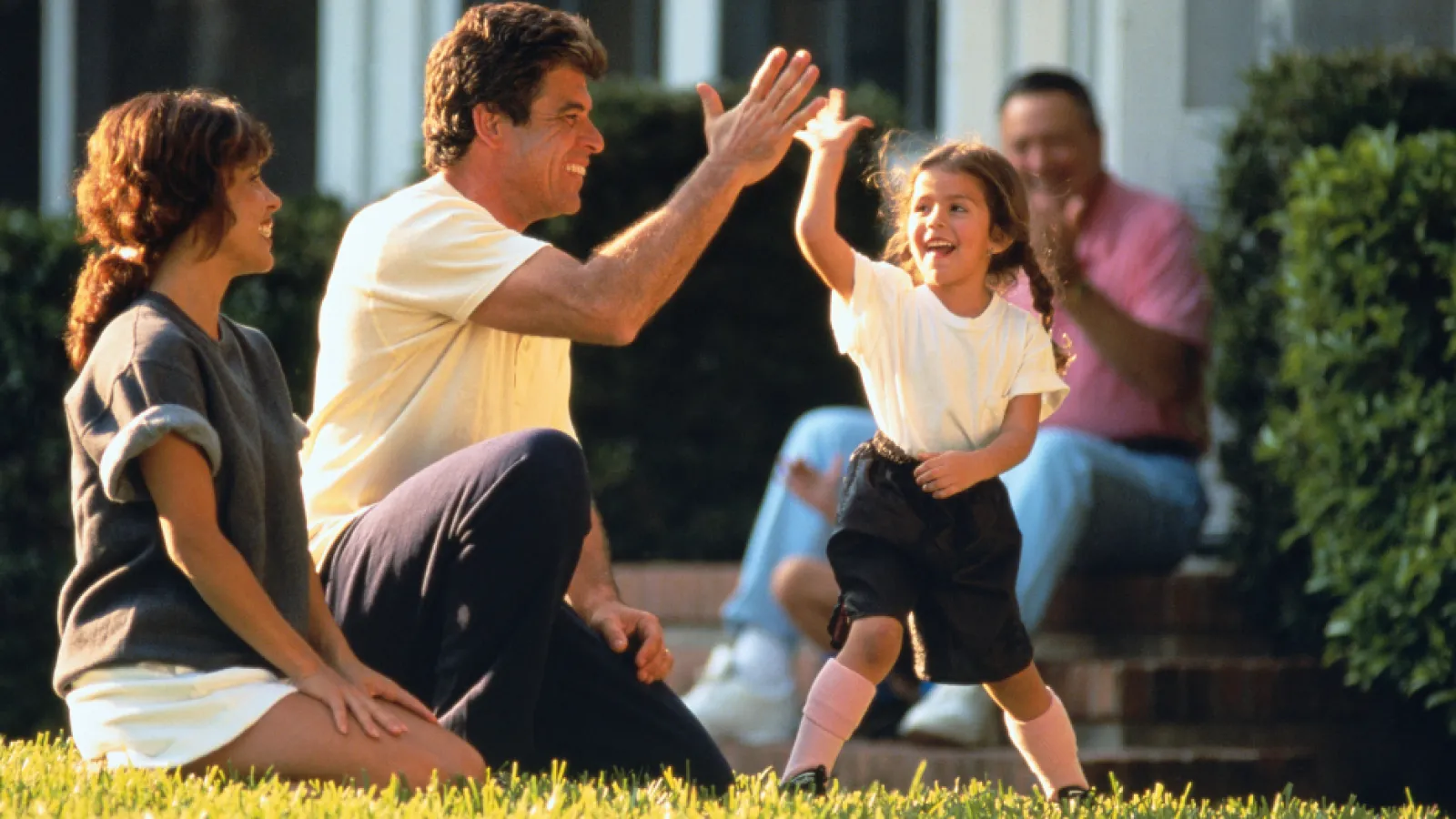 family high fiving in lawn