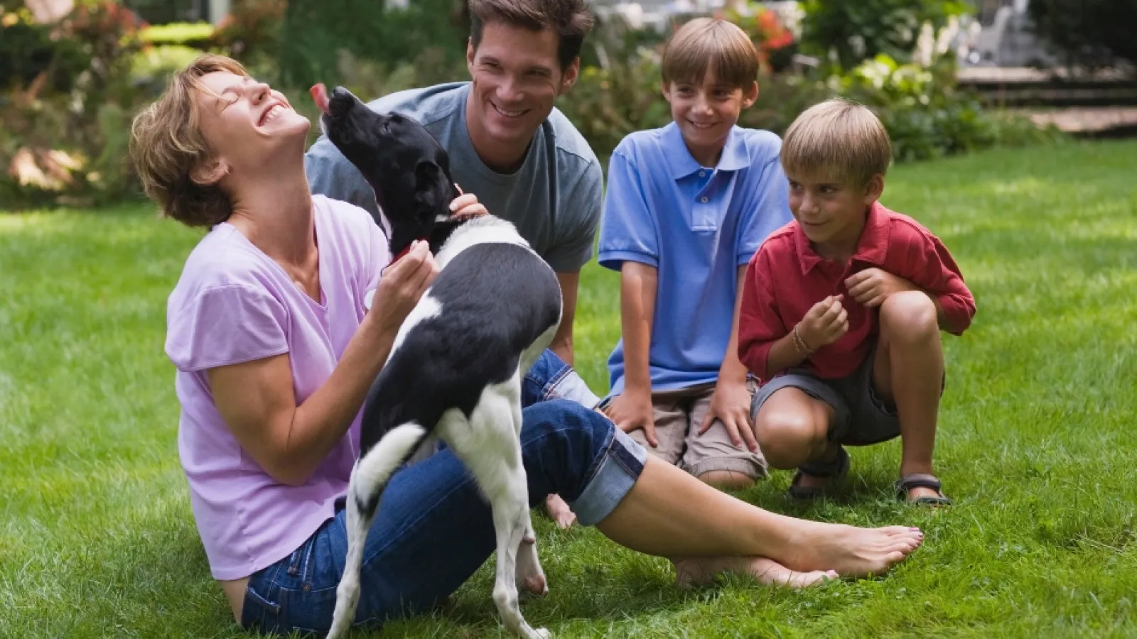 a group of people sitting on grass with a dog