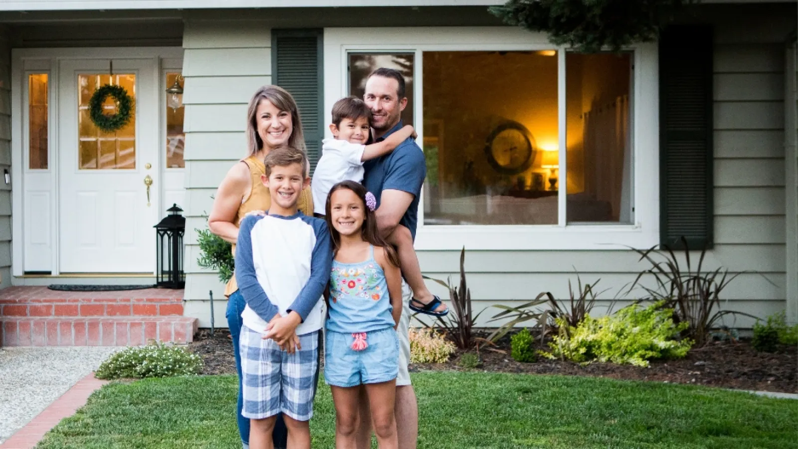 a group of people posing for a photo in front of a house