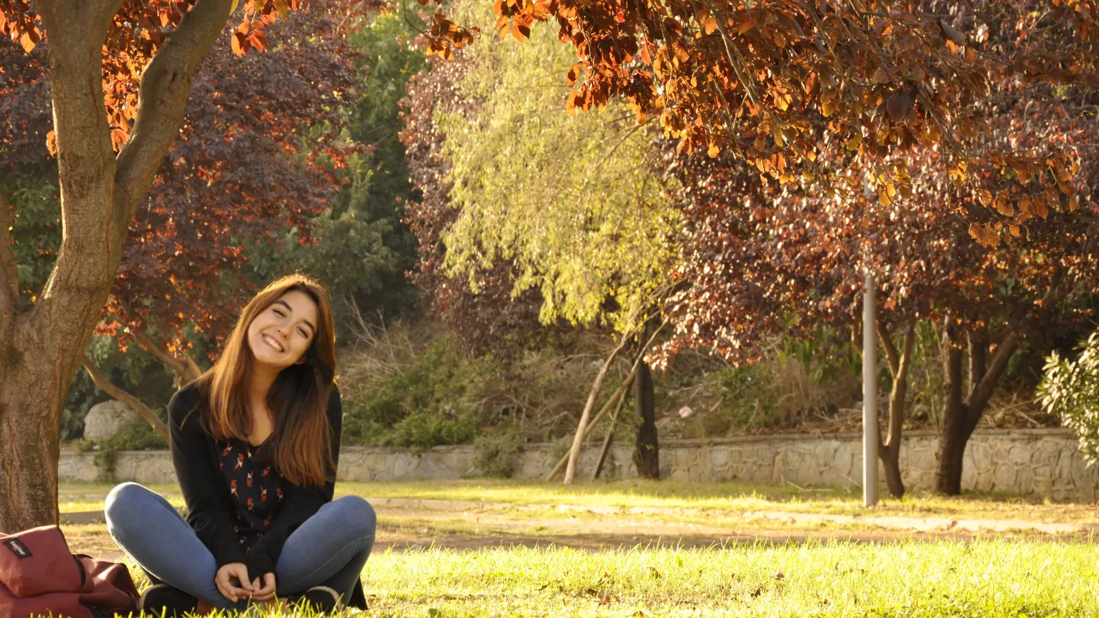 girl sitting in grass in the fall