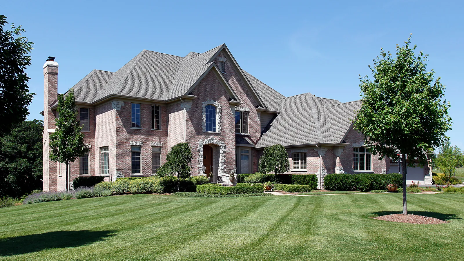 a large brick house with a green lawn
