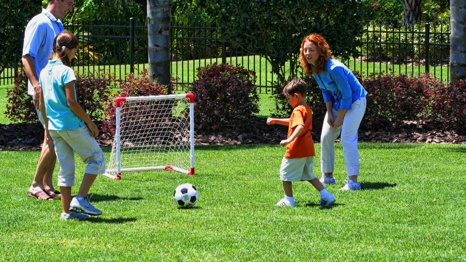 family playing soccer in the yard