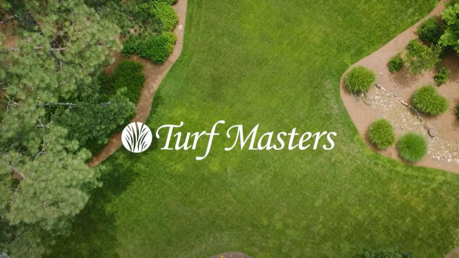 Aerial view of a landscaped green lawn with trees and shrubs, featuring Turf Masters logo in the center.