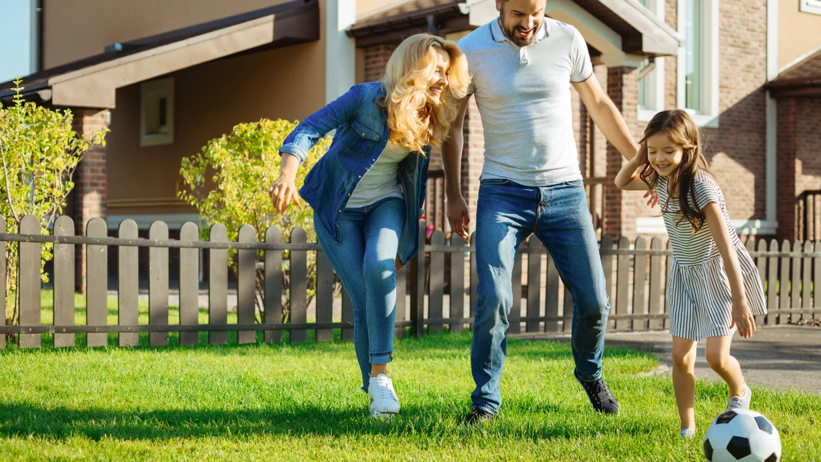 Family playing soccer in a weed free lawn