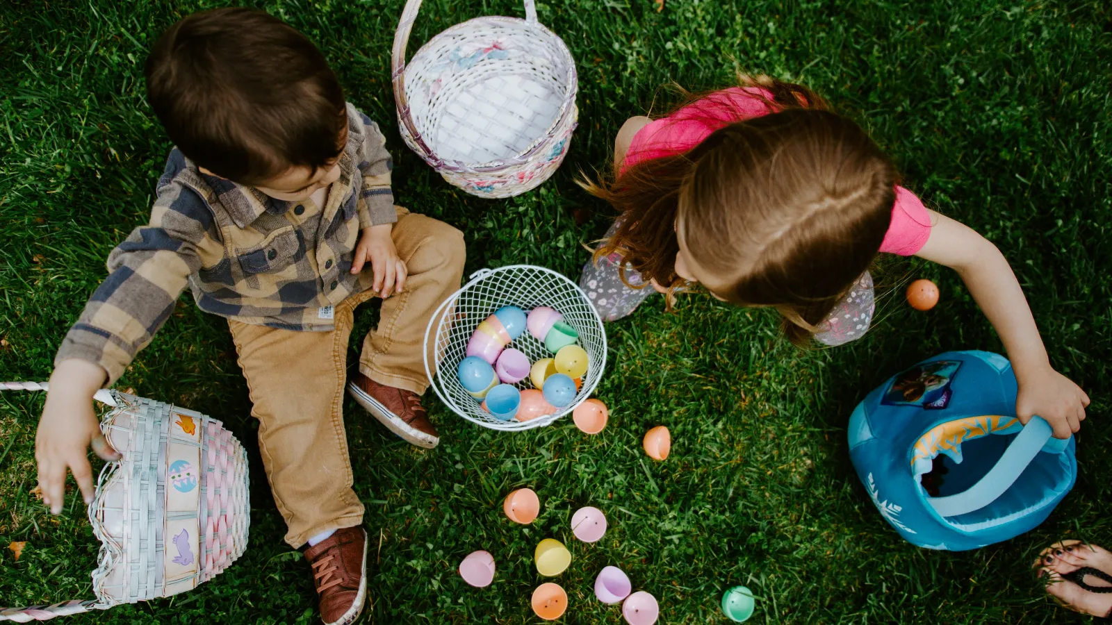 children sitting in grass with easter baskets