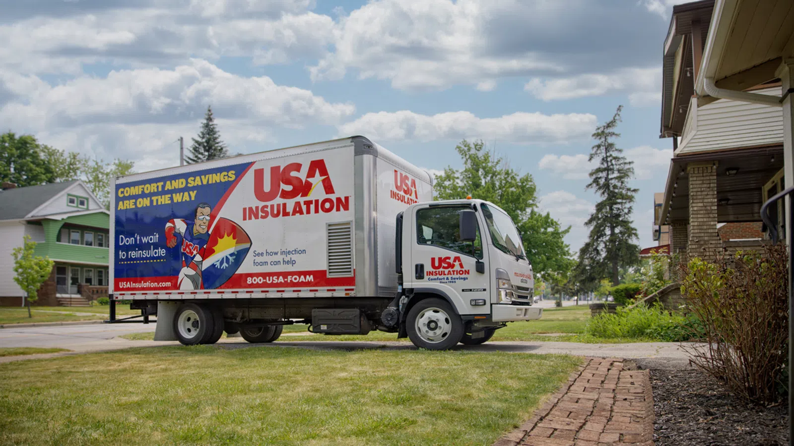 USA Insulation truck parked on a residential street with branded graphics promoting foam insulation services.