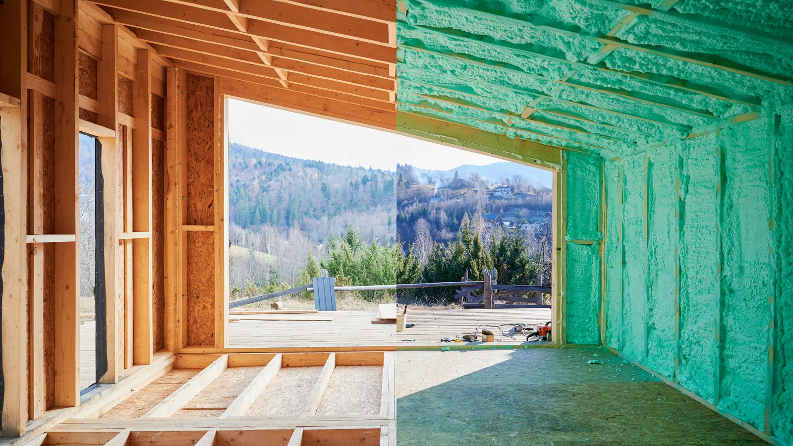 Interior view of a house under construction with wooden framing and green spray foam insulation.