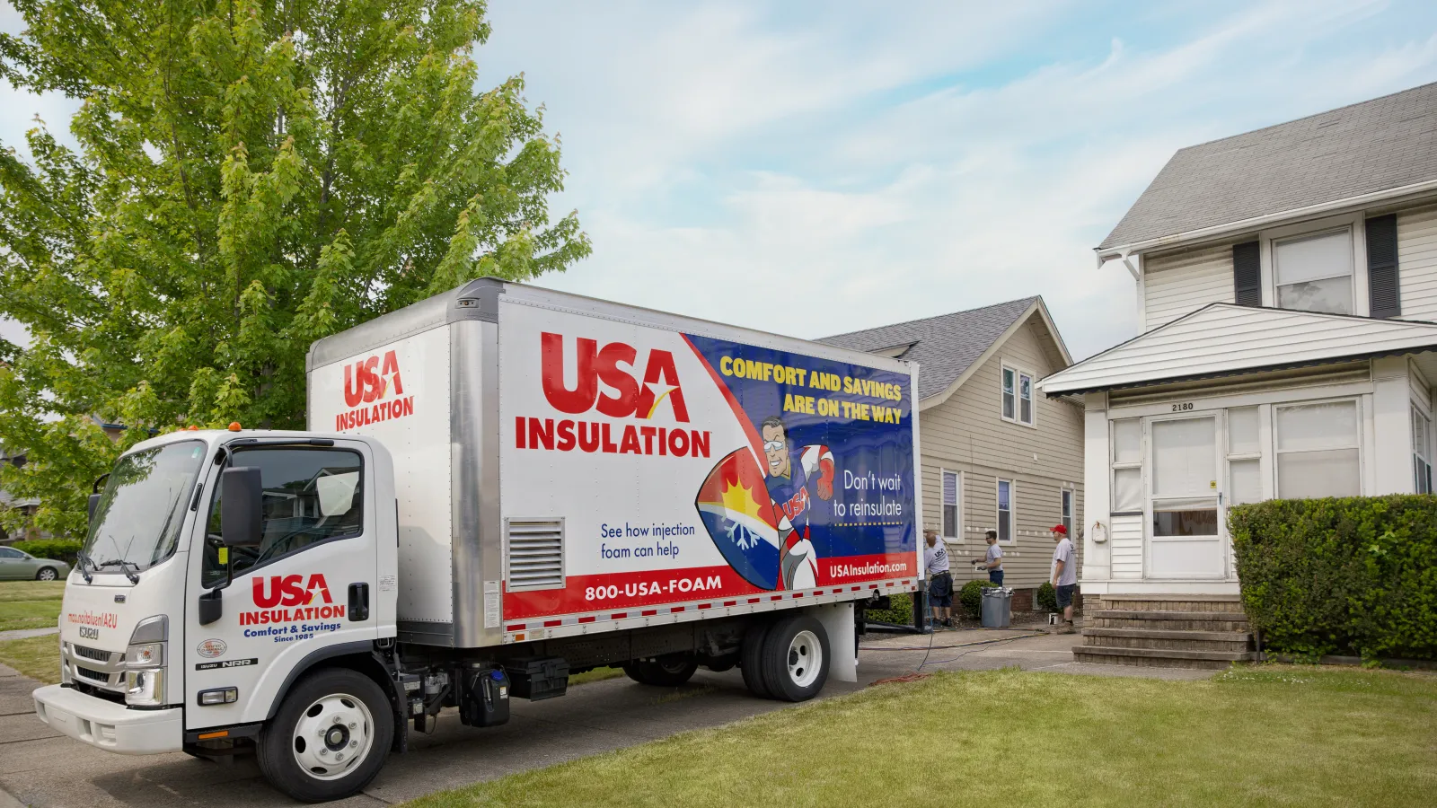 A USA Insulation truck parked in front of a house