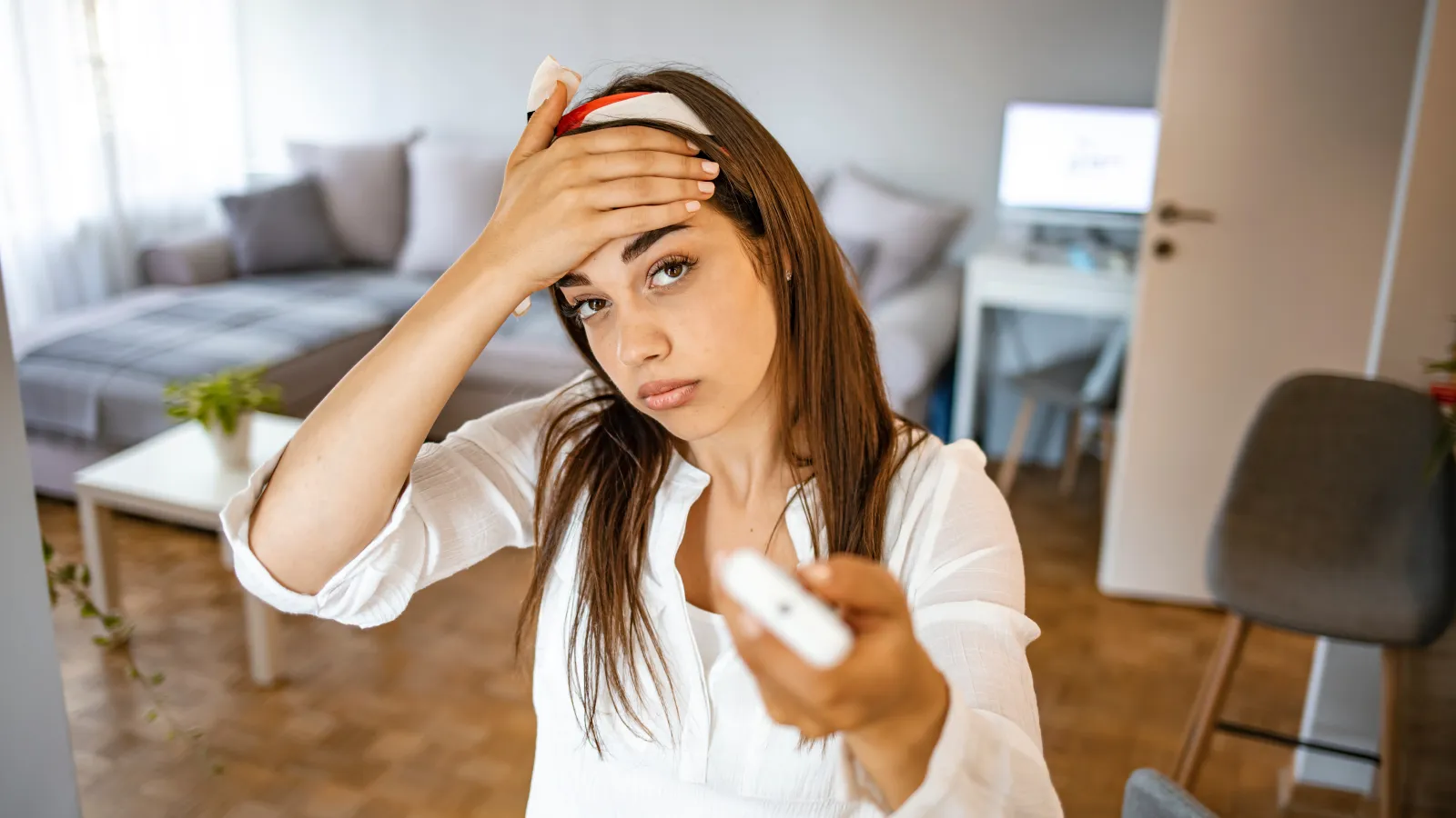 a woman holding a remote and her head