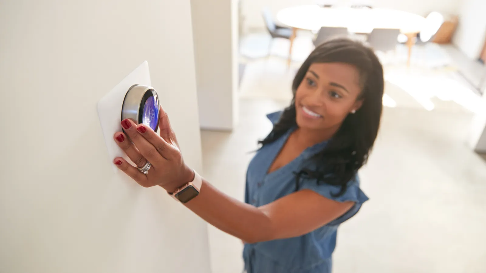 a woman interacting with her thermostat