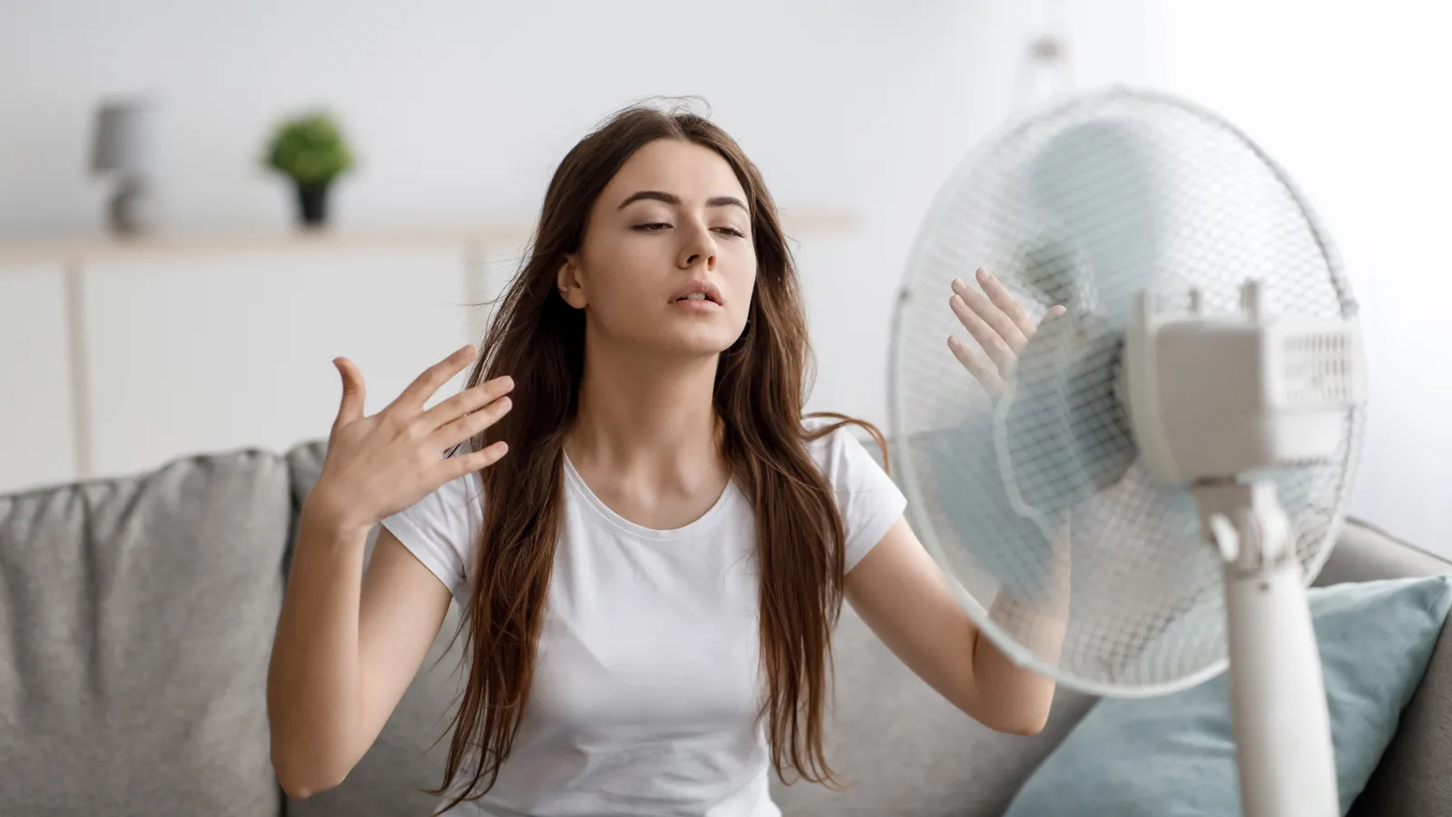 a woman sitting in front of a fan