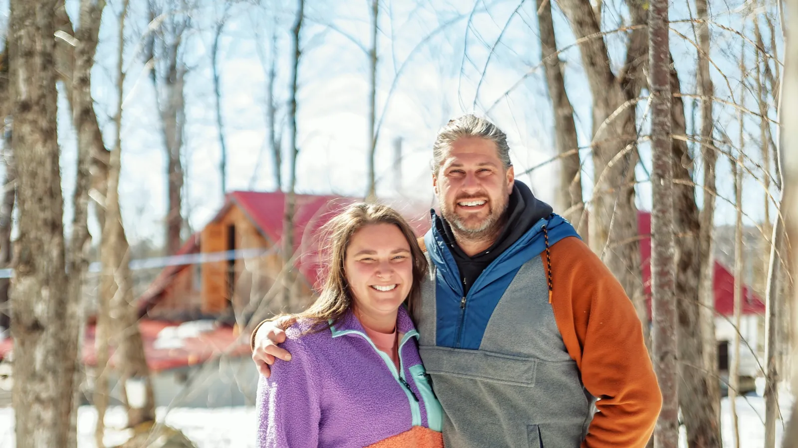 a man and woman standing in the snow