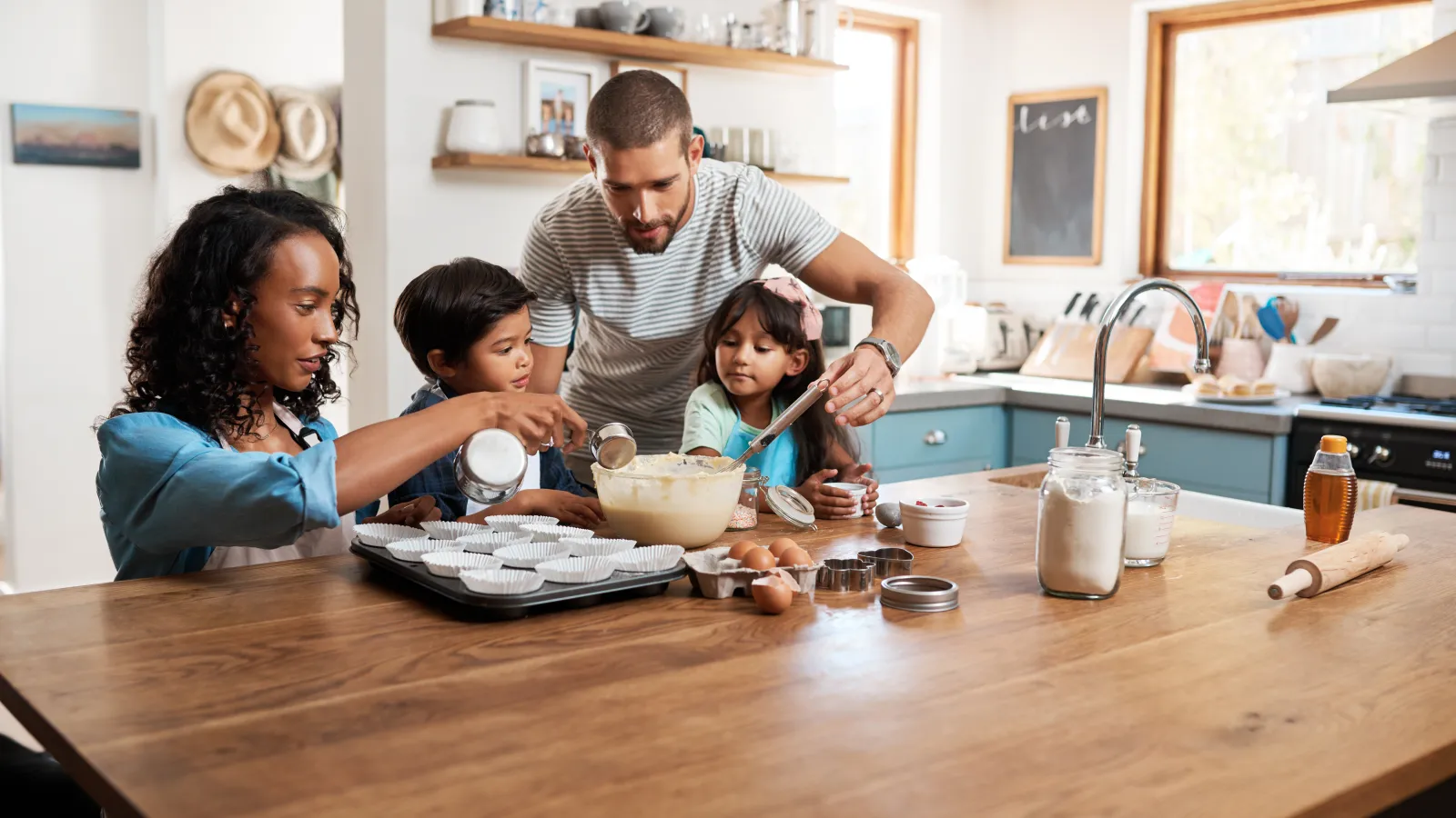 Family baking together in a modern kitchen, sharing quality time and fun with children.