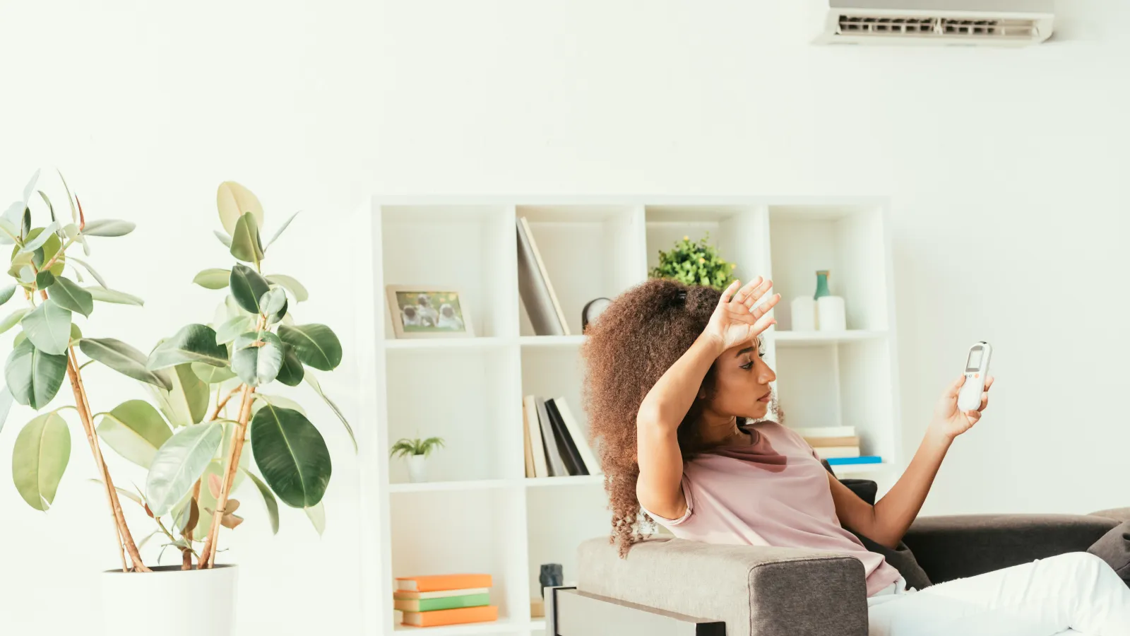 a women sitting on a couch holding a remote