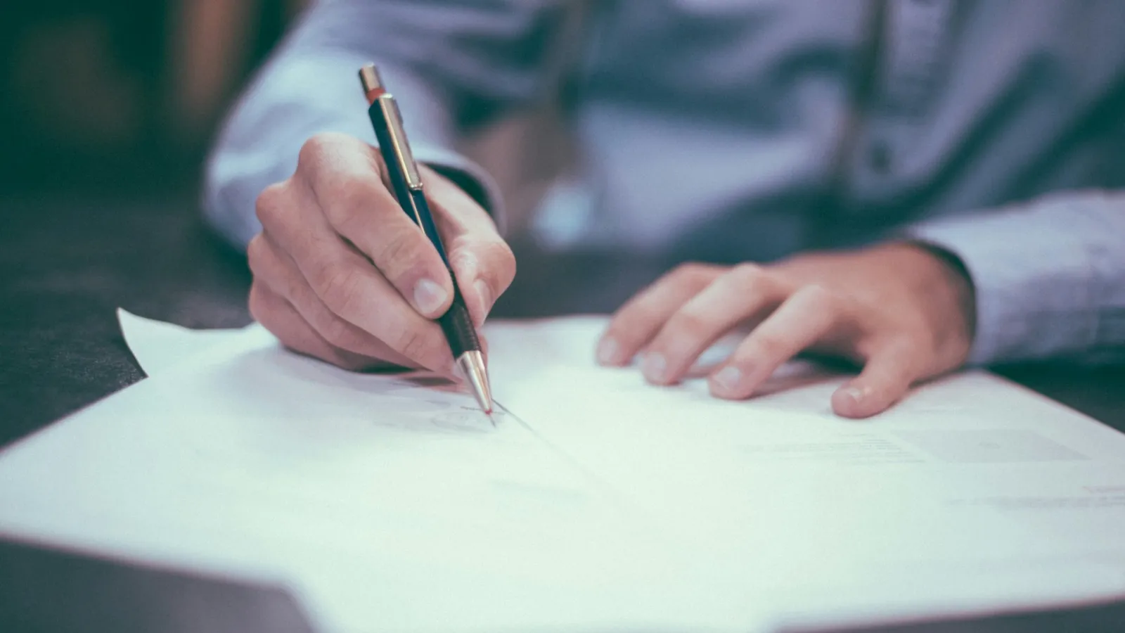 a person writing on a piece of paper