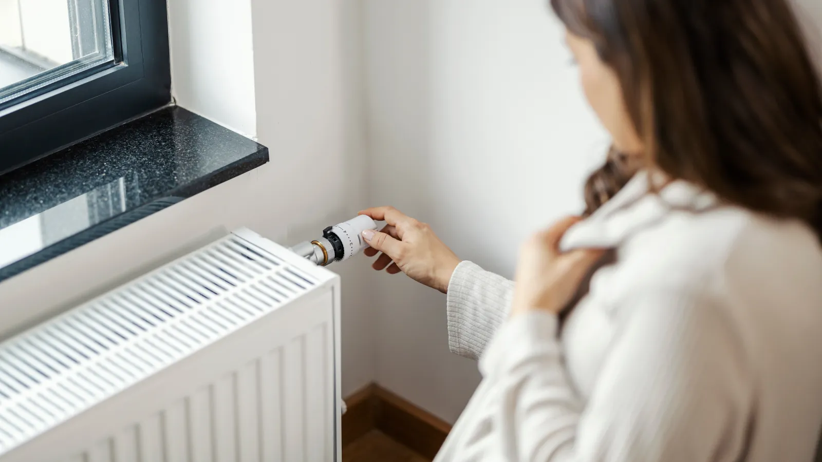 a woman next to a heating unit