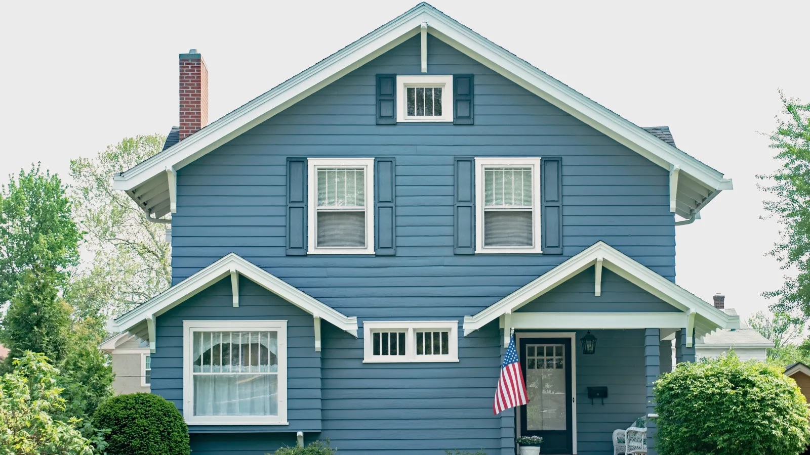 a blue house with a flag on the roof