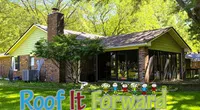 Brick house with a chimney surrounded by green lawn and trees under bright sunlight with Roof It Forward logo.