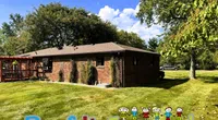 Brick house with green lawn and trees under a blue sky featuring colorful Roof It Forward logo with children graphics.